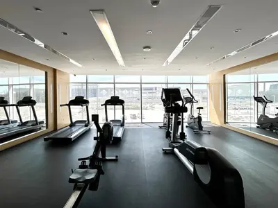 a gym with treadmills and machines in a building at Homes2Retreat - Chic & Cozy Studio in Damac in Dubai