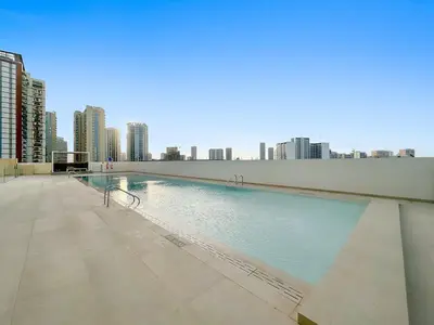 a large swimming pool with a city in the background at FIRST CLASS Studio Touch of Luxury & Comfort in Dubai