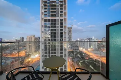 a balcony with a table and chairs and a view of a city at FIRST CLASS Studio Touch of Luxury & Comfort in Dubai