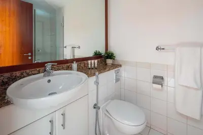a white bathroom with a sink and a toilet at Frank Porter - Al Yass Tower in Dubai