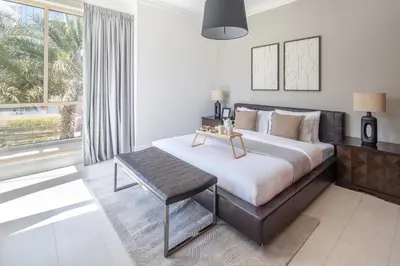 a bedroom with a bed with a table and a window at Frank Porter - Al Yass Tower in Dubai