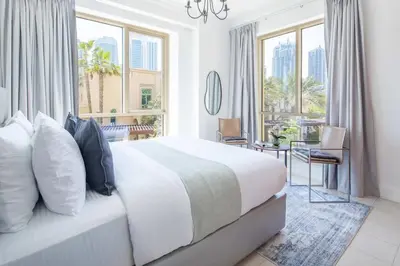 a bedroom with a bed and a desk and windows at Frank Porter - Al Yass Tower in Dubai