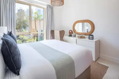 a bedroom with a bed and a mirror and a window at Frank Porter - Al Yass Tower in Dubai