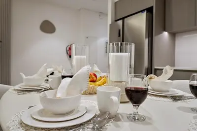 a table with white dishes and wine glasses on it at FIRST CLASS 2BR Burj Khalifa & Fountain view in Dubai