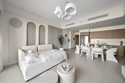 a living room with a white couch and a kitchen at FIRST CLASS 2BR Burj Khalifa & Fountain view in Dubai