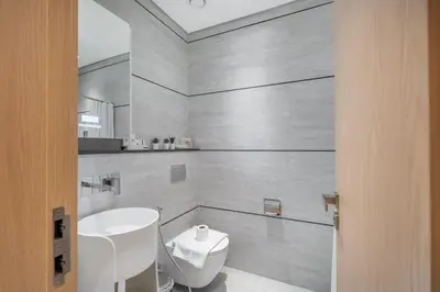 a bathroom with a white toilet and a sink at Modern Studio by Czechin JVC Prime Location in Dubai