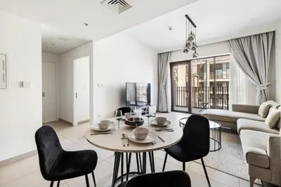 a living room with a table and chairs and a couch at 1BR Summer 4 Direct Beach Access in Dubai