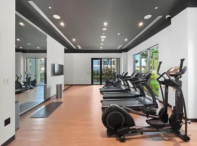 a gym with a row of treadmills and ellipticals at 1BR Summer 4 Direct Beach Access in Dubai