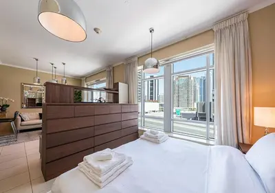 a bedroom with a large white bed with a large window at Luxurious Studio in Downtown Dubai in Dubai