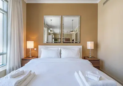 a bedroom with a large white bed with two mirrors at Luxurious Studio in Downtown Dubai in Dubai