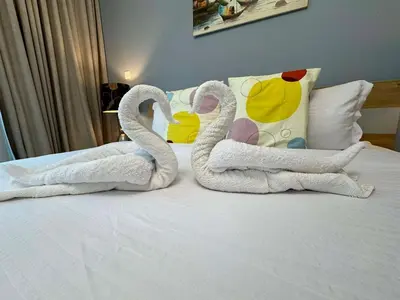 two swans made out of towels sitting on a bed at Spacious and Family Friendly l 3BHK Full Apartment Access in Dubai