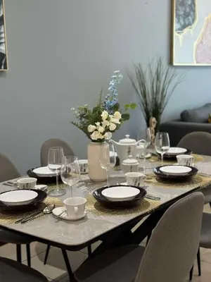 a table with plates and wine glasses on it at Spacious and Family Friendly l 3BHK Full Apartment Access in Dubai