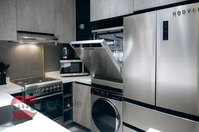 a kitchen with a stainless steel refrigerator and a dishwasher at Royal style New 1BR with a view in Dubai