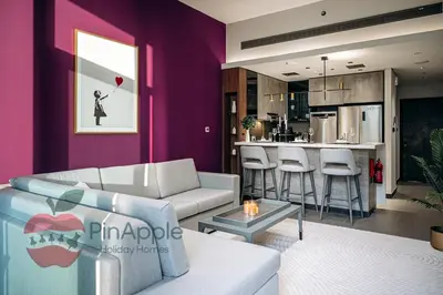 a living room with a couch and a kitchen at Royal style New 1BR with a view in Dubai