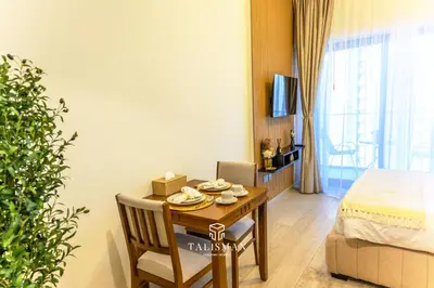 a living room with a table and a bed and a room at Modern Studio in Azizi Riviera, Meydan in Dubai