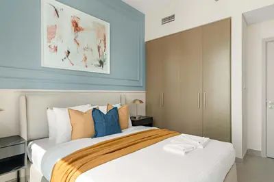 a bedroom with a large bed with blue walls at Silkhaus Cozy 1BDR at Forte Tower in Emaar Downtown in Dubai