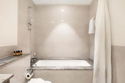 a bathroom with a bath tub and a shower at Silkhaus Cozy 1BDR at Forte Tower in Emaar Downtown in Dubai