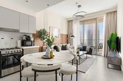 a kitchen and living room with a table and chairs at Silkhaus Cozy 1BDR at Forte Tower in Emaar Downtown in Dubai
