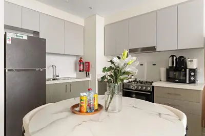 a kitchen with a table with a vase of flowers at Silkhaus Cozy 1BDR at Forte Tower in Emaar Downtown in Dubai
