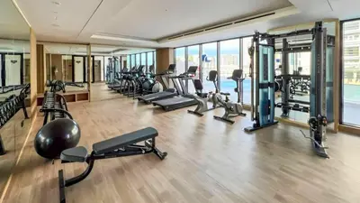 a gym with several treadmills and cardio machines at TRPS - Binghatti Nova, Jumeirah Village Circle - Premium 1BR with Great Amenities in Dubai