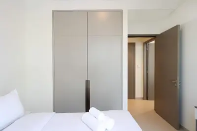 a bedroom with white walls and a large glass closet at Livbnb-Modern 2BR with Partial Burj Khalifa View in Dubai