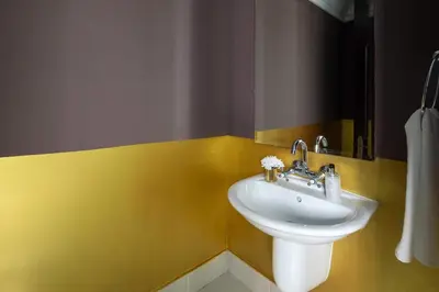 a bathroom with a sink and a yellow wall at Frank Porter - Tejar Tower in Dubai