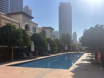 a swimming pool with chairs and umbrellas in a city at Frank Porter - Tejar Tower in Dubai