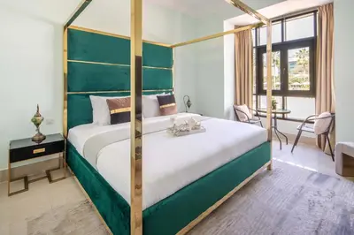 a bedroom with a large bed with a green headboard at Frank Porter - Tejar Tower in Dubai