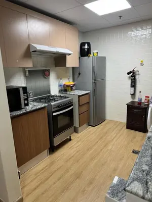 a kitchen with stainless steel appliances and wooden floors at Supper holly days home in Dubai