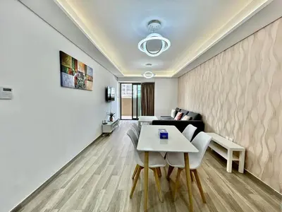a living room with a couch and a table at Homes2Retreat - Serene 1BR Getaway with Stunning Views in Dubai