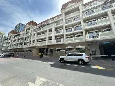a white car parked in front of a building at Homes2Retreat - Serene 1BR Getaway with Stunning Views in Dubai