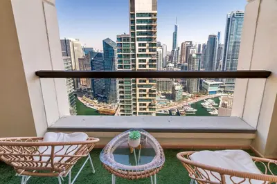 a balcony with two chairs and a view of a city at GuestReady - Chic High-Rise with Canal Views in Dubai