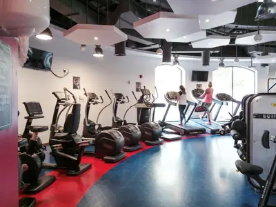 a gym with many treadmills and people in it at GuestReady - Chic High-Rise with Canal Views in Dubai