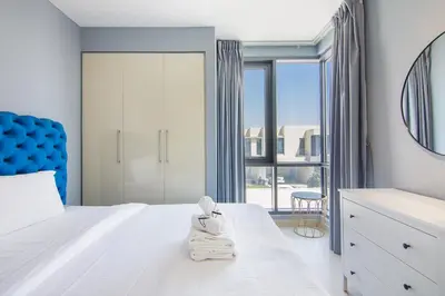 a bedroom with a white bed with a blue headboard at Elegant 4 bedrooms plus maid Villa in the Heart of Dubai Hills in Dubai