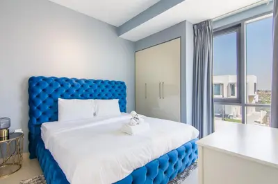 a blue bed in a room with a large window at Elegant 4 bedrooms plus maid Villa in the Heart of Dubai Hills in Dubai