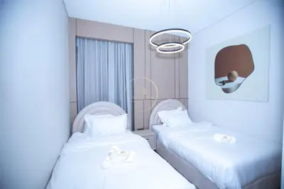 two beds in a hospital room with white sheets at 3BHK Apartment located in Azizi riviera 34 in Dubai