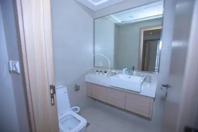 a bathroom with a sink and a toilet and a mirror at 3BHK Apartment located in Azizi riviera 34 in Dubai