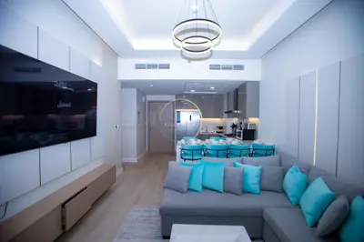 a living room with a gray couch and blue pillows at 3BHK Apartment located in Azizi riviera 34 in Dubai