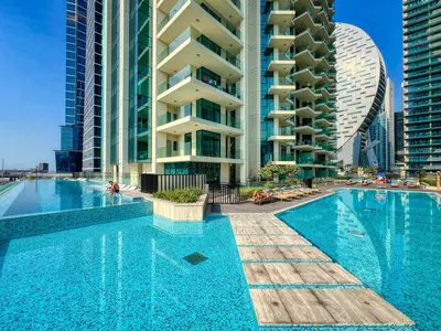 a swimming pool in front of some tall buildings at The Smart Concierge - Urban Oasis by Missoni in Dubai