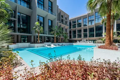 an image of a swimming pool in front of a building at Escape24 Cozy Studio with Pool View in JVC in Dubai