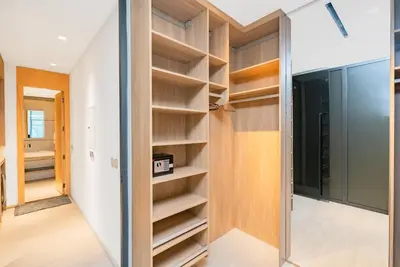 a walk in closet with wooden shelves at Escape24 Cozy Studio with Pool View in JVC in Dubai