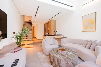 a living room with a couch and a table at Escape24 Cozy Studio with Pool View in JVC in Dubai