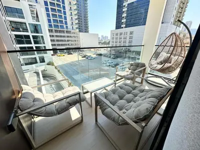 two chairs on a balcony with a view of a city at Spacious Luxury 1br Jvc Balcony & Pool in Dubai