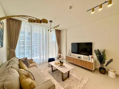 a living room with a couch and a flat screen tv at Spacious Luxury 1br Jvc Balcony & Pool in Dubai