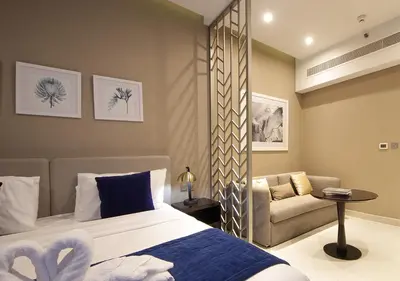 a bedroom with a bed and a chair and a couch at Elegant Studio with Canal Views DAMAC Prive in Dubai