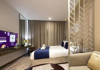 a hotel room with a bed and a flat screen tv at Elegant Studio with Canal Views DAMAC Prive in Dubai