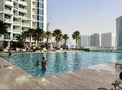 a man standing in a swimming pool in a city at Elegant Studio with Canal Views DAMAC Prive in Dubai