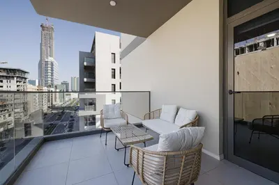 a balcony with two chairs and a table on a building at Daniels 2BR at Jumeirah Garden City in Dubai
