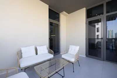 a balcony with two chairs and a table and a couch at Daniels 2BR at Jumeirah Garden City in Dubai