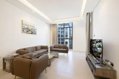 a living room with a couch and a tv at Daniels 2BR at Jumeirah Garden City in Dubai